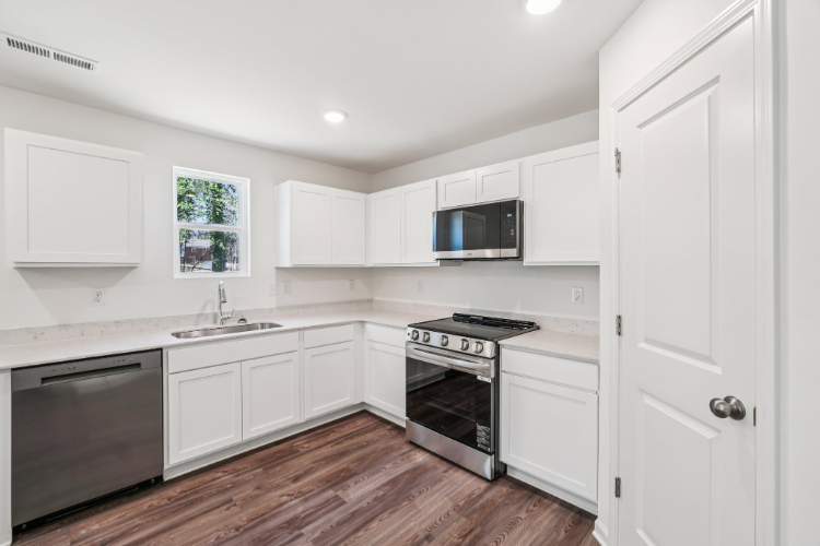 A kitchen with white cabinets.