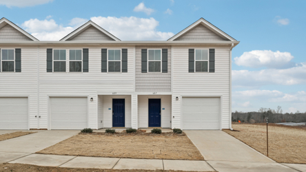 A white house with garages.