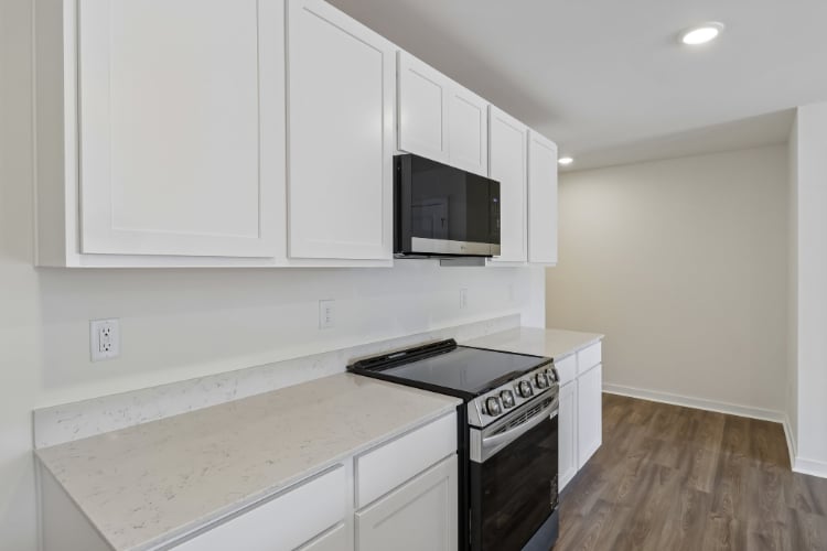 A kitchen with white cabinets.