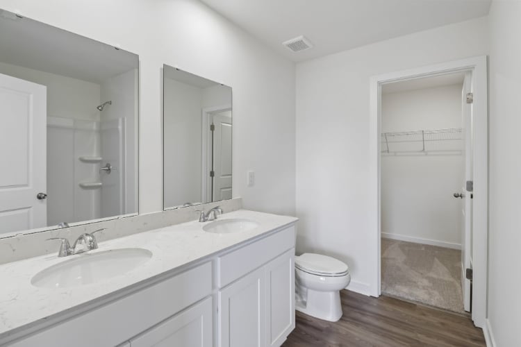 A bathroom with a toilet sink and mirror.