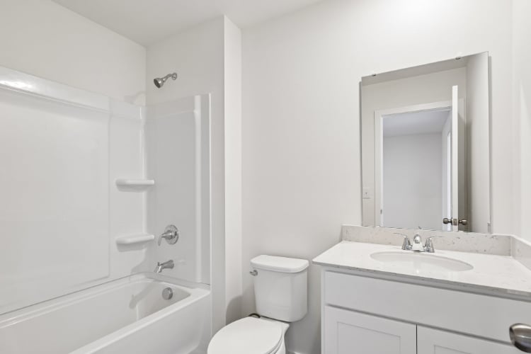 A bathroom with a tub sink and toilet.