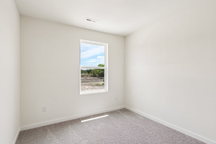 A room with a window and a view of the ocean.