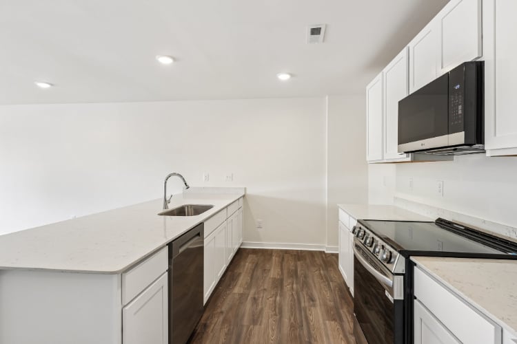 A kitchen with white cabinets.