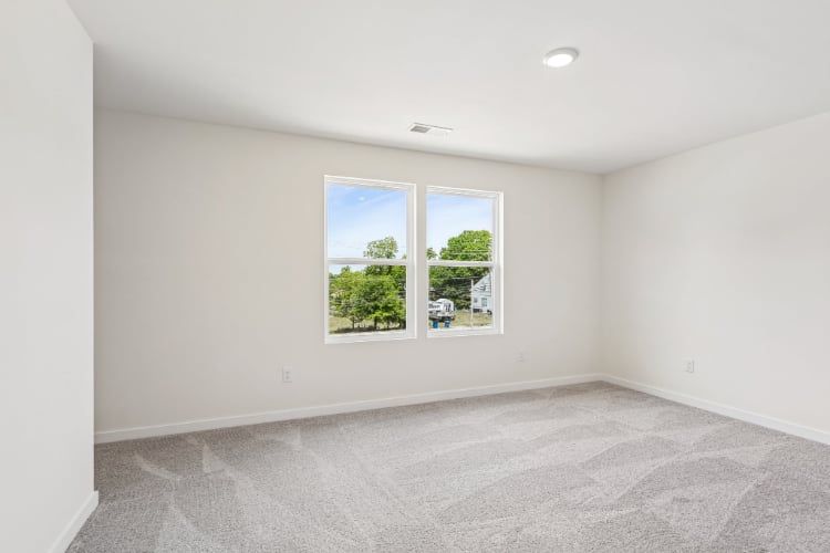 A room with a window and a carpet.