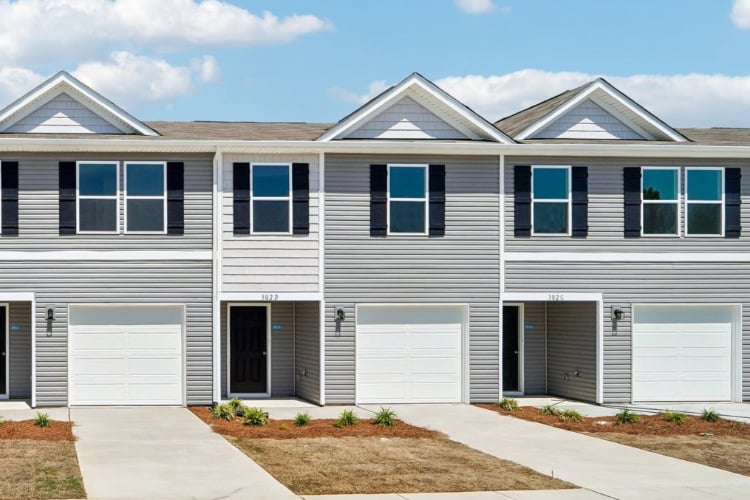 A white house with garages.