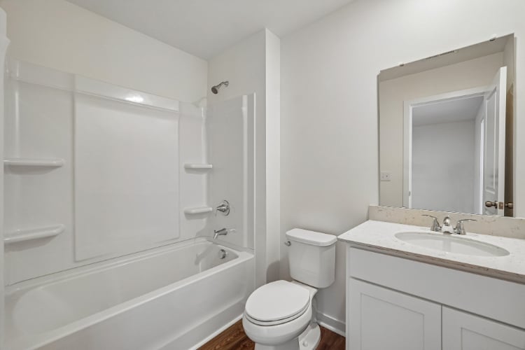 A bathroom with a tub sink and toilet.