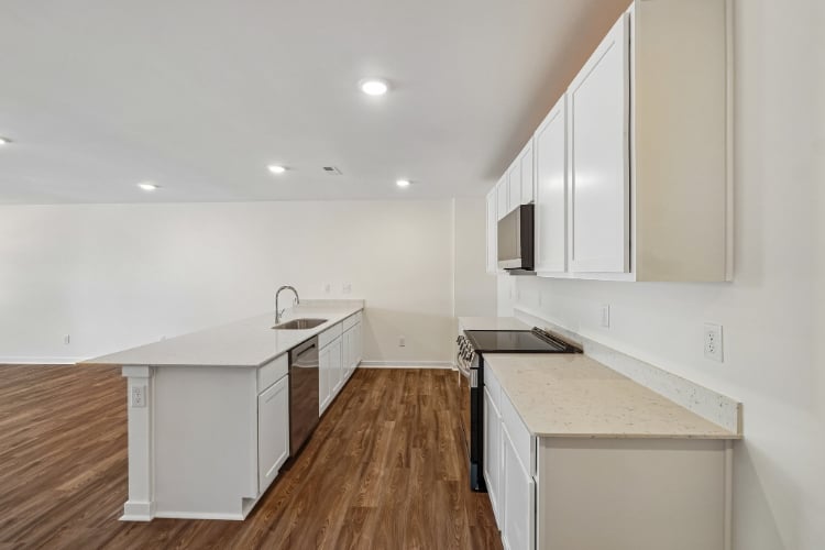A kitchen with white cabinets.