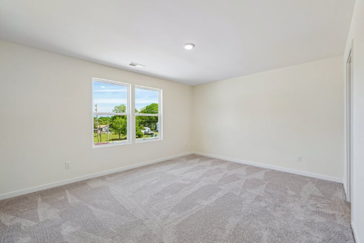 A room with a window and a carpet.