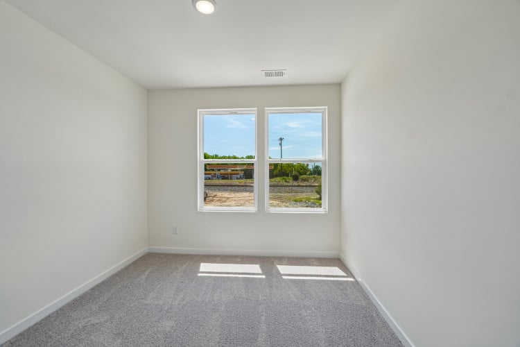 A room with a window and a rug.