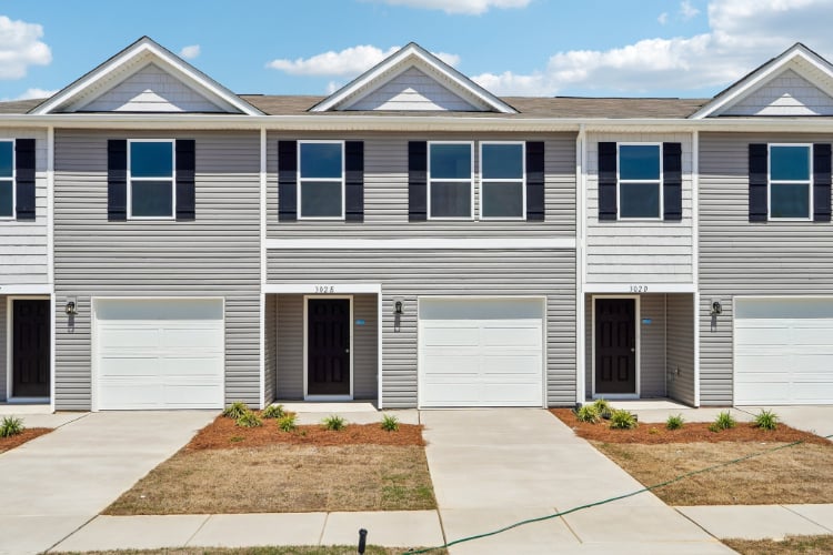 A white house with garages.