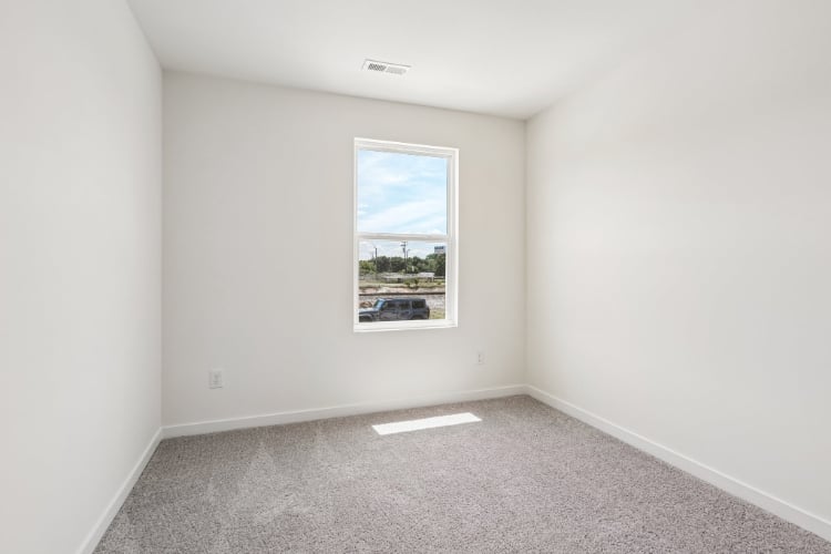 A room with a window and a picture on the wall.