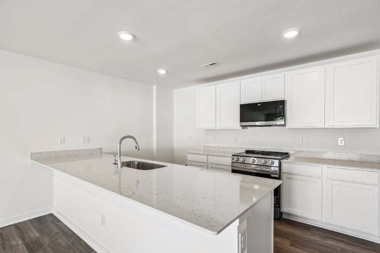 A kitchen with white cabinets.