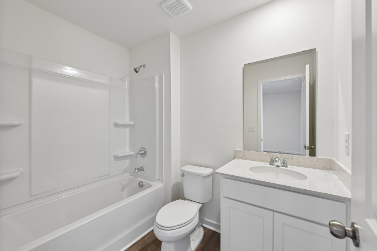 A bathroom with a tub sink and toilet.