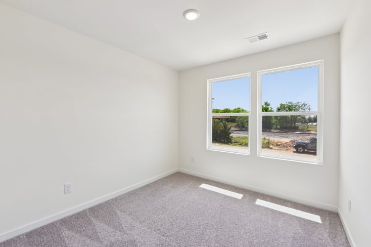 A room with a window and a door with a view of the ocean.