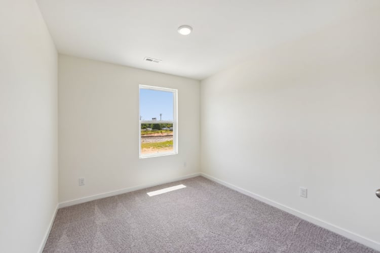 A room with a window and a carpet.