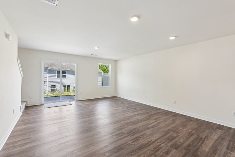 A large empty room with a wood floor and a wood floor.