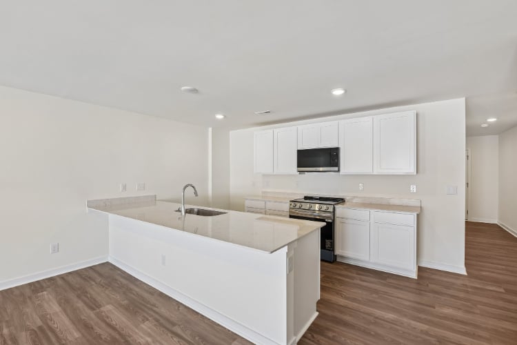 A kitchen with white cabinets.