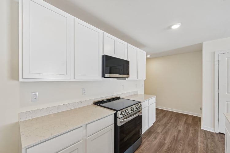 A kitchen with white cabinets.