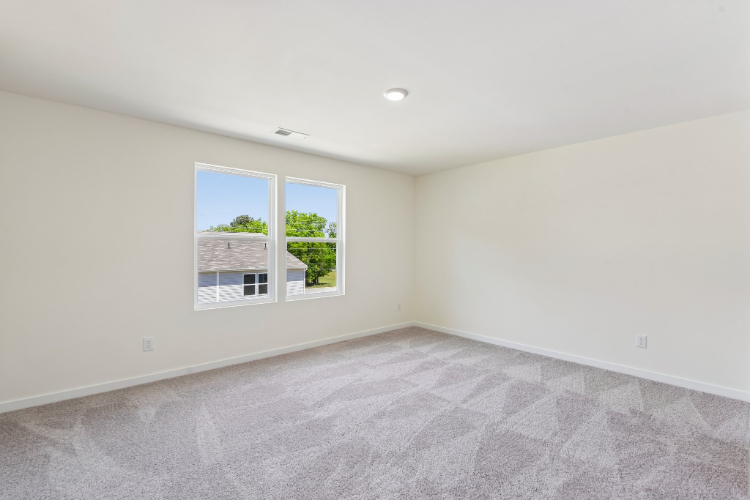 A room with a window and a rug.