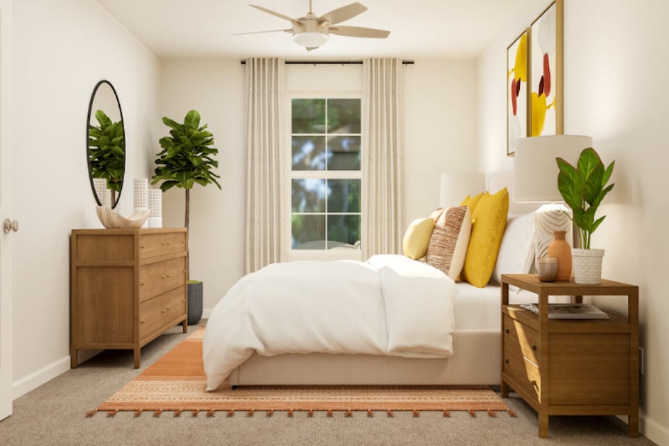 A living room with a white couch and a fan.