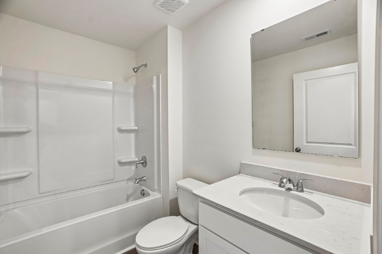 A bathroom with a tub sink and toilet.