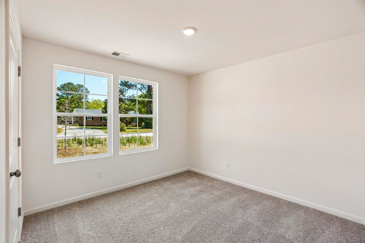 A room with a window and a carpet.