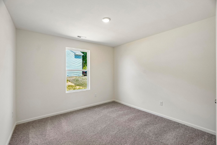 A room with a window and carpet.