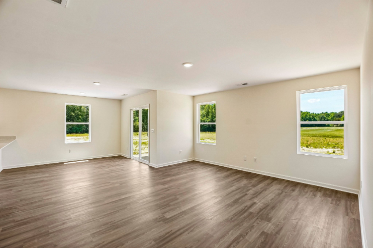 A room with a wood floor and windows.