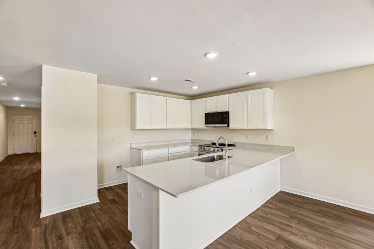 A kitchen with white cabinets.
