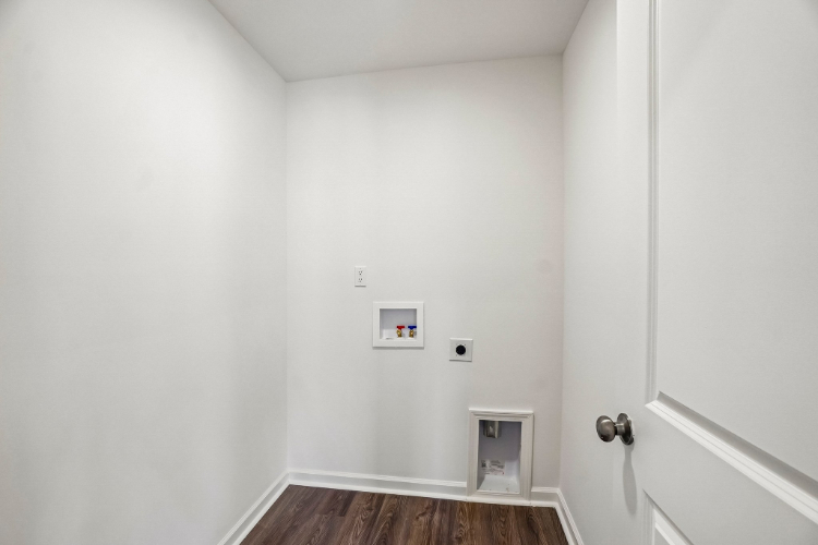 A white room with a wood floor.