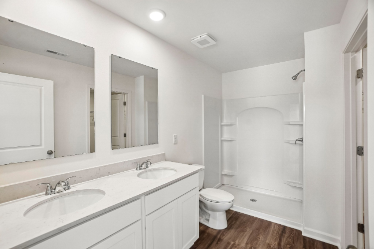 A bathroom with a toilet sink and mirror.
