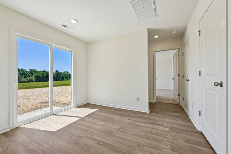 A room with a wood floor and a large window.