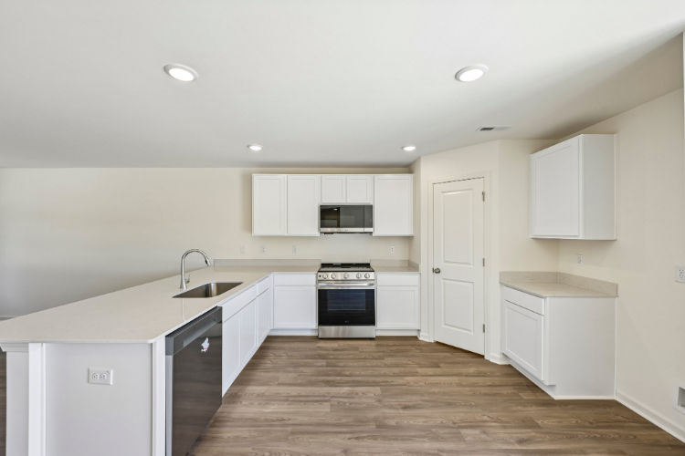 A kitchen with white cabinets.