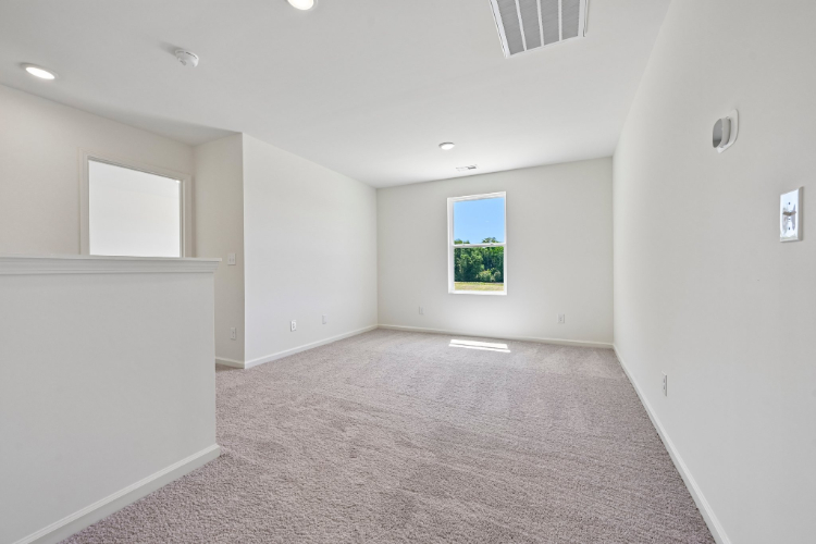 A room with a window and a carpet.