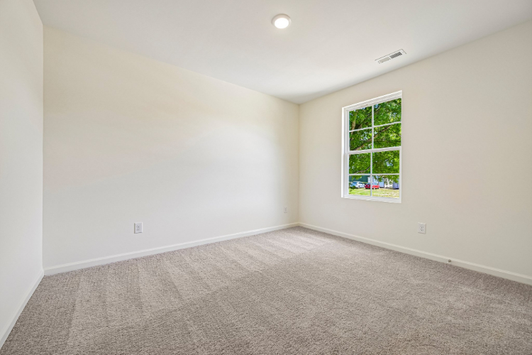 A room with a window and carpet.