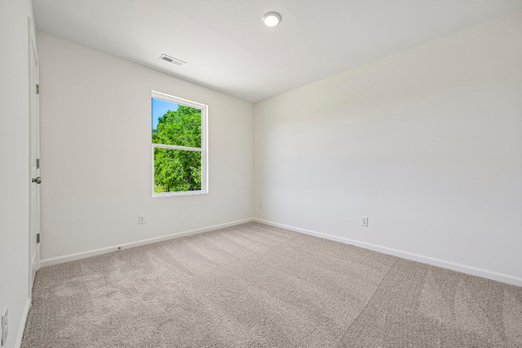 A room with a window and a carpet.