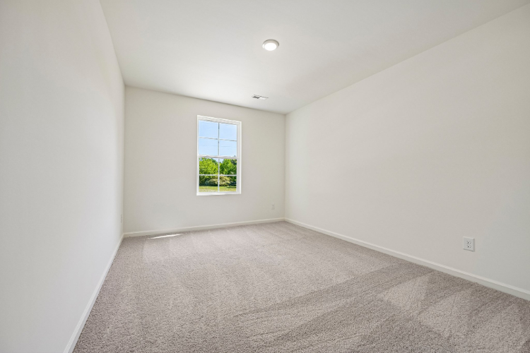 A room with a window and a carpet.