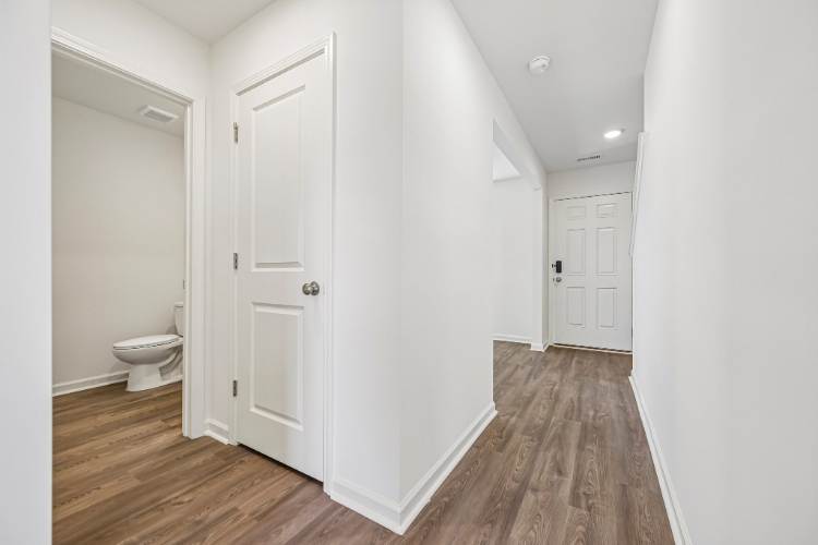 A bathroom with white cabinets.