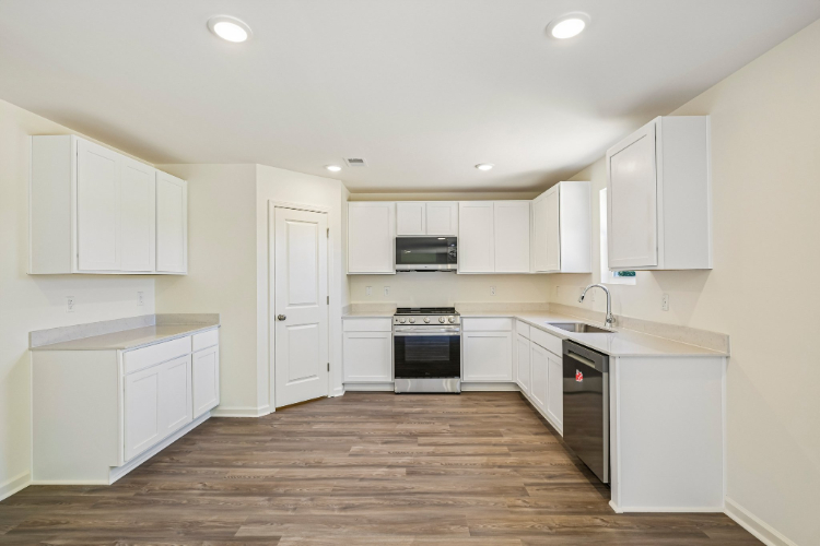 A kitchen with white cabinets.