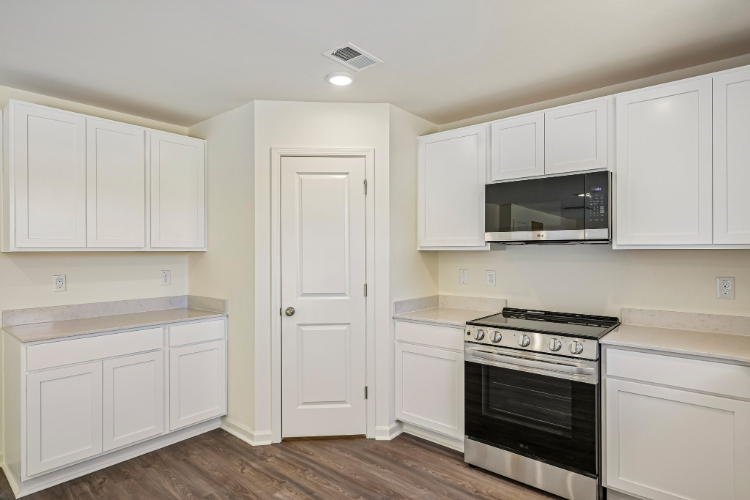 A kitchen with white cabinets.