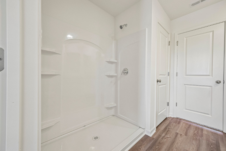 A bathroom with white cabinets.
