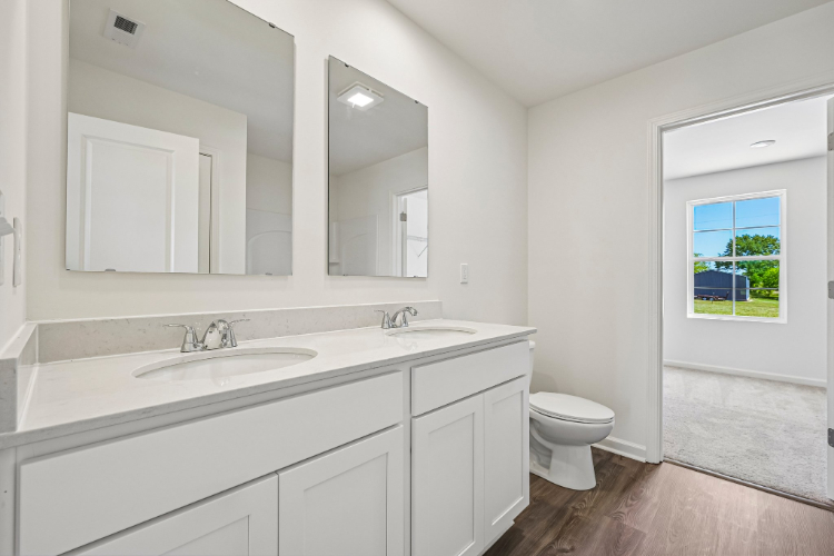 A bathroom with white cabinets.