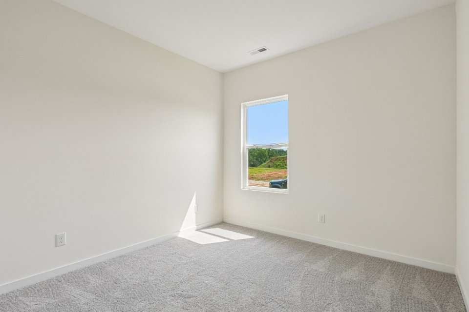 A room with a window and a carpet.