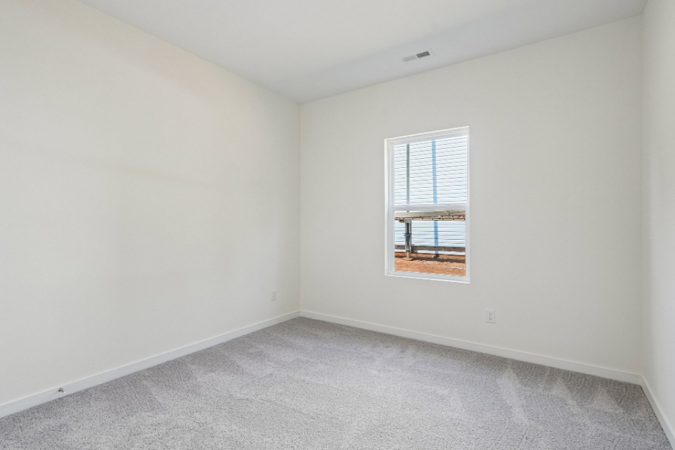 A room with a window and a carpet.