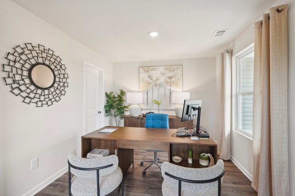 A room with a desk and chairs.