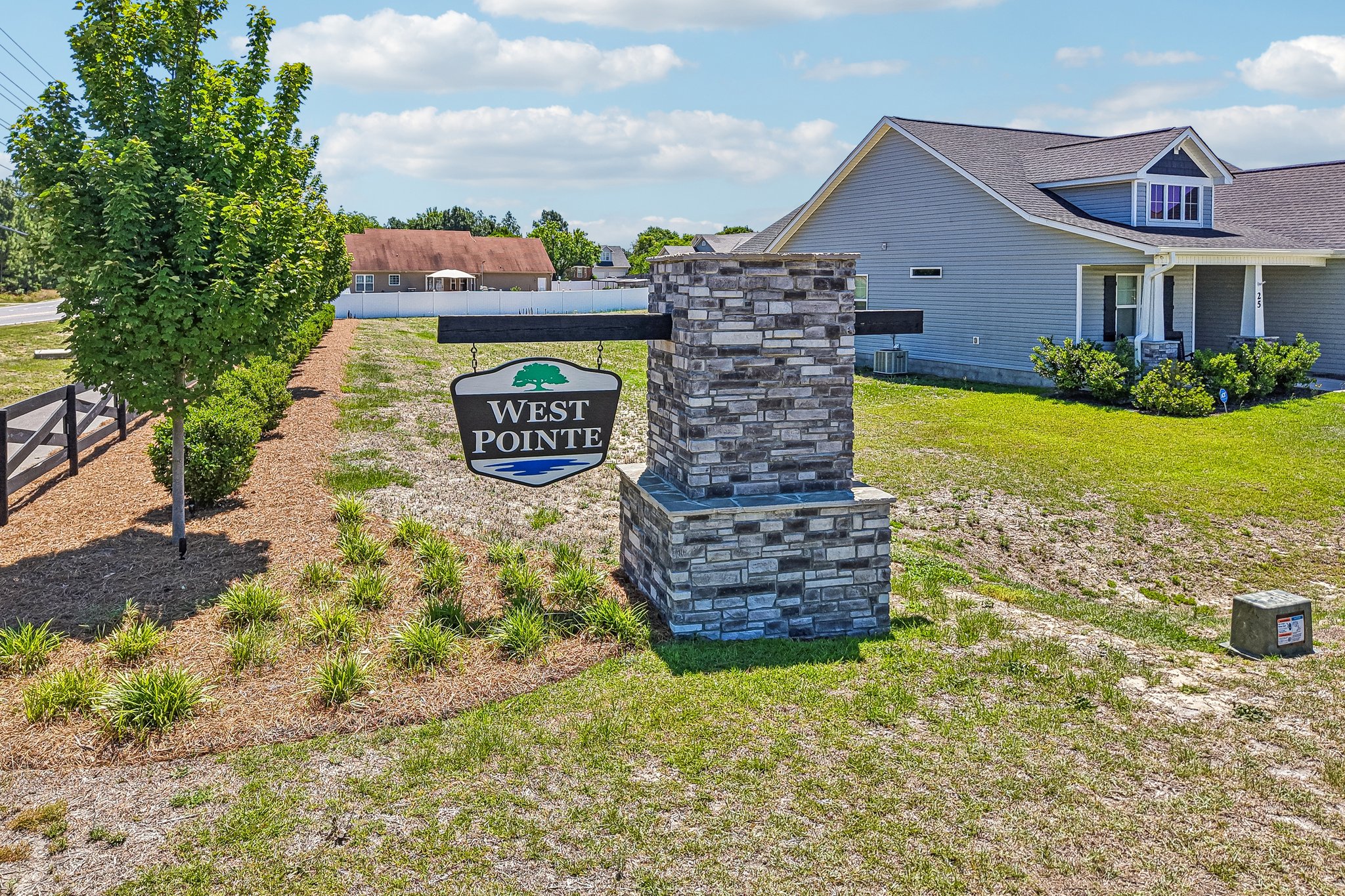 A stone structure in a grassy area with a sign in the front.