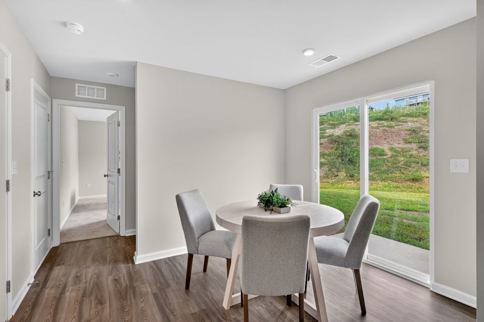 A dining room with a table and chairs.
