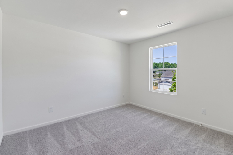 A room with a window and a carpet.