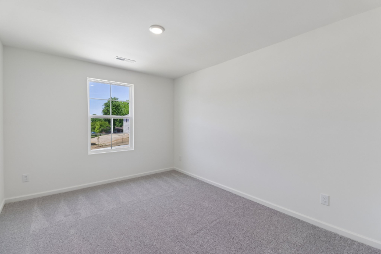 A room with a window and a carpet.
