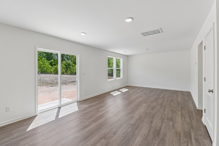 A room with a wood floor and windows.